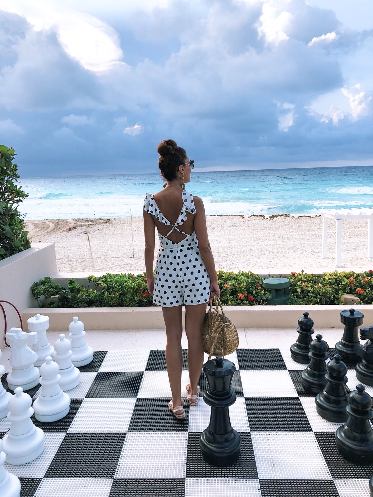 Elegant Duchess Fashion ASOS DESIGN Cut Out Ruffle Playsuit In Spot | Miu Miu sunglasses | South Beach Round Gold Woven Straw Cross Body Bag | Glamourous Pearl Sandals | ASOS DESIGN Wrapped Bead & Tassel Earrings